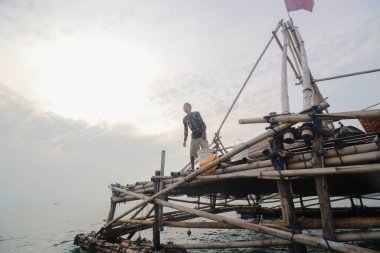 Sukabumi, Batı Java, Endonezya - 15 Haziran 2021: Endonezyalı geleneksel balıkçılar, sabahları pagang veya bagang (bambudan yapılmış geleneksel balıkçılık aleti) avlarını azaltmak için birlikte çalışırlar