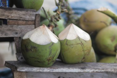 Masada iki yeşil hindistan cevizi ve bulanık arka plan.