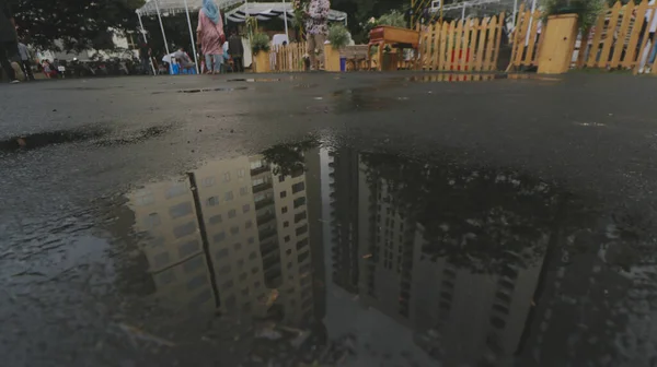 昼間の雨の後の水溜り内のマンション及びマンションの建物の反射のクローズアップ — ストック写真