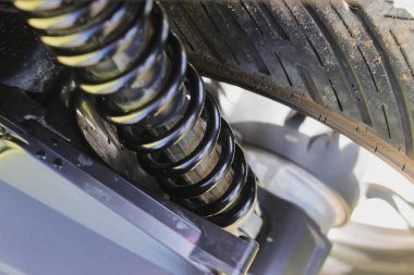 Motosiklet şoku kırıcının ya da arka tekerlekteki şok emicinin yakın görüntüsü. Motosiklet aksesuarları, Garaj ve Hizmetler Konsepti.