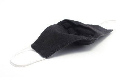 Beyaz kayışlı yeniden kullanılabilir siyah bez maske beyaz arkaplanda izole edilmiş Covid-19 yayılmasını önler..