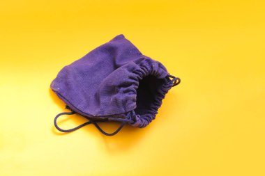 Mücevherleri tutmak için küçük kumaş kesesi ve turuncu arka planda izole edilmiş günlük eşyalar. Seyahat malzemeleri için kullanılabilir çantalar