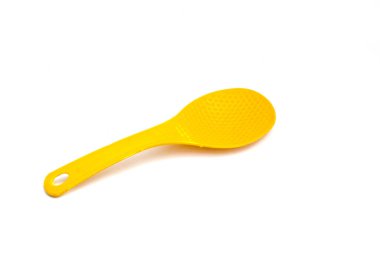 Beyaz zemin üzerinde izole edilmiş sarı plastik pirinç kaşığı