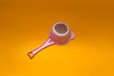 Eski kullanılan pembe plastik çay süzgeci (süzgeç) turuncu arka planda izole edilmiş
