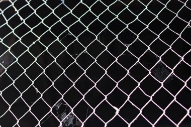 Terk edilmiş tel örgüler, örümcek ağı ve siyah çözünmüş arka plan. Terk edilmiş evin, hapishane bariyerinin, güvenli mülkün soyut arkaplanı.