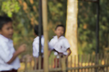 Purwakarta, West Java, Endonezya - 07 Eylül 2019: Sınıfın önünde kırmızı ve beyaz üniformalı Endonezyalı ilköğretim öğrencilerinin soyut geçmişi arkadaşlarıyla oynuyor