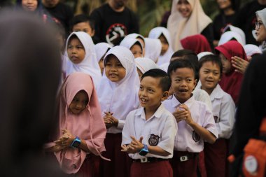 Purwakarta, Batı Java, Endonezya - 07 Eylül 2019: Beyaz ve kırmızı üniformalı mutlu Endonezyalı ilkokul öğrencileri eğitim için sınıfa girmeye hazırlanıyor