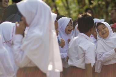 Purwakarta, Batı Java, Endonezya - 07 Eylül 2019: Beyaz ve kırmızı üniformalı mutlu Endonezyalı ilkokul öğrencileri eğitim için sınıfa girmeye hazırlanıyor