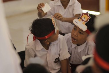 Purwakarta, Batı Java, Endonezya - 07 Eylül 2019: Beyaz ve kırmızı üniformalı Endonezyalı ilkokul öğrencileri sınıfta tartışıyorlar