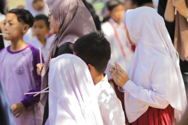 Purwakarta, Batı Java, Endonezya - 07 Eylül 2019: Beyaz ve kırmızı üniformalı Endonezyalı ilkokul öğrencileri sınıfın önünde oynuyor