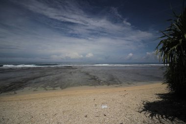 Mavi gökyüzü ve görkemli bulutlarıyla güzel tropik plaj Cibuaya Plajı Ujung Genteng Sukabumi, Batı Java, Endonezya.
