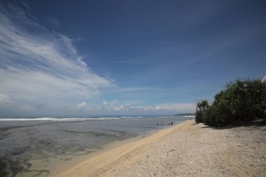 Mavi gökyüzü ve görkemli bulutlarıyla güzel tropik plaj Cibuaya Plajı Ujung Genteng Sukabumi, Batı Java, Endonezya.