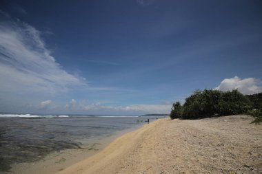 Mavi gökyüzü ve görkemli bulutlarıyla güzel tropik plaj Cibuaya Plajı Ujung Genteng Sukabumi, Batı Java, Endonezya.