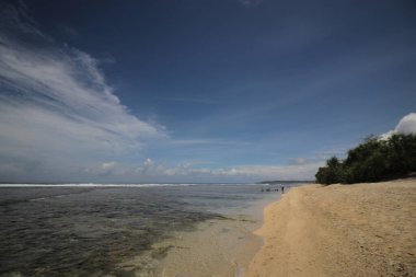 Mavi gökyüzü ve görkemli bulutlarıyla güzel tropik plaj Cibuaya Plajı Ujung Genteng Sukabumi, Batı Java, Endonezya.