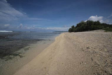 Mavi gökyüzü ve görkemli bulutlarıyla güzel tropik plaj Cibuaya Plajı Ujung Genteng Sukabumi, Batı Java, Endonezya.