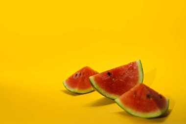 Turuncu arka planda izole edilmiş taze olgun karpuz dilimlerinin yakın görüntüsü. Tropikal meyveler, sağlıklı beslenme ve yaz dönemi konsepti..