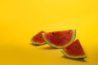 Turuncu arka planda izole edilmiş taze olgun karpuz dilimlerinin yakın görüntüsü. Tropikal meyveler, sağlıklı beslenme ve yaz dönemi konsepti..