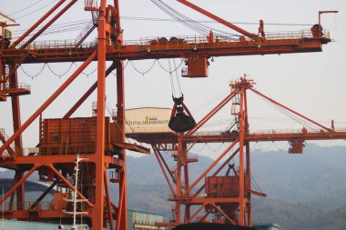 Sukabumi, Batı Java, Endonezya - 23 Ağustos 2021: Kömür ateşiyle çalışan buhar santralinin manzarası kanat vinci ile Pelabuhan Ratu kıyısı yakınlarındaki gemi kargosundan kömür stoklarını kaldırıyor..