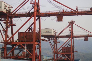 Sukabumi, Batı Java, Endonezya - 23 Ağustos 2021: Kömür ateşiyle çalışan buhar santralinin manzarası kanat vinci ile Pelabuhan Ratu kıyısı yakınlarındaki gemi kargosundan kömür stoklarını kaldırıyor..