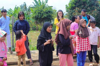 Sukabumi, Batı Java, Endonezya - 19 Ağustos 2021: Endonezya halkı, Endonezya Bağımsızlık Günü 'nde arka bahçede geleneksel oyunlar oynamak için ailelerini izlemek üzere toplanıyor.