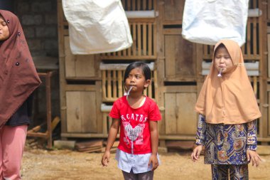 Sukabumi, Batı Java, Endonezya - 19 Ağustos 2021: Endonezya Bağımsızlık Günü boyunca Endonezya 'nın geleneksel oyunu Balap Kereveng veya Mermer Yarışı adı verilen bir grup mutlu Endonezyalı çocuk oynuyor.