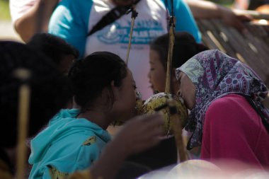 Sukabumi, Batı Java, Endonezya - 17 Ağustos 2020: Endonezyalı çocuklar SIGIT adı verilen geleneksel oyunlar oynuyorlar veya Endonezya Bağımsızlık Günü sırasında soya sosuyla kaplı portakal meyvelerinden madeni paralar alıyorlar