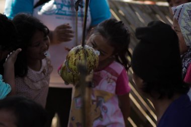 Sukabumi, Batı Java, Endonezya - 17 Ağustos 2020: Endonezyalı çocuklar SIGIT adı verilen geleneksel oyunlar oynuyorlar veya Endonezya Bağımsızlık Günü sırasında soya sosuyla kaplı portakal meyvelerinden madeni paralar alıyorlar