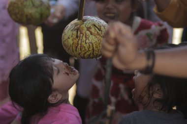 Sukabumi, Batı Java, Endonezya - 17 Ağustos 2020: Endonezyalı çocuklar SIGIT adı verilen geleneksel oyunlar oynuyorlar veya Endonezya Bağımsızlık Günü sırasında soya sosuyla kaplı portakal meyvelerinden madeni paralar alıyorlar