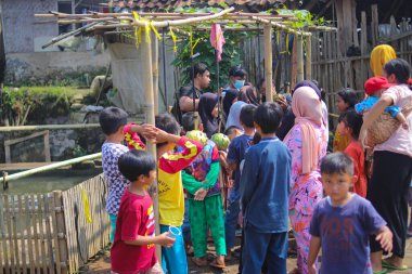 Sukabumi, Batı Java, Endonezya - 19 Ağustos 2021: Endonezyalı çocuklar SIGIT adı verilen geleneksel oyunlar oynuyorlar veya Endonezya Bağımsızlık Günü sırasında soya sosuyla kaplı portakal meyvelerinden madeni para alıyorlar