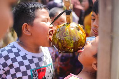 Sukabumi, Batı Java, Endonezya - 19 Ağustos 2021: Endonezyalı çocuklar SIGIT adı verilen geleneksel oyunlar oynuyorlar veya Endonezya Bağımsızlık Günü sırasında soya sosuyla kaplı portakal meyvelerinden madeni para alıyorlar