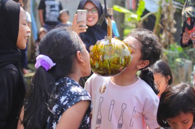 Sukabumi, Batı Java, Endonezya - 19 Ağustos 2021: Endonezyalı çocuklar SIGIT adı verilen geleneksel oyunlar oynuyorlar veya Endonezya Bağımsızlık Günü sırasında soya sosuyla kaplı portakal meyvelerinden madeni para alıyorlar