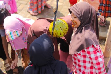 Sukabumi, Batı Java, Endonezya - 19 Ağustos 2021: Endonezyalı çocuklar SIGIT adı verilen geleneksel oyunlar oynuyorlar veya Endonezya Bağımsızlık Günü sırasında soya sosuyla kaplı portakal meyvelerinden madeni para alıyorlar