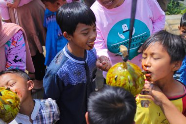 Sukabumi, Batı Java, Endonezya - 19 Ağustos 2021: Endonezyalı çocuklar SIGIT adı verilen geleneksel oyunlar oynuyorlar veya Endonezya Bağımsızlık Günü sırasında soya sosuyla kaplı portakal meyvelerinden madeni para alıyorlar