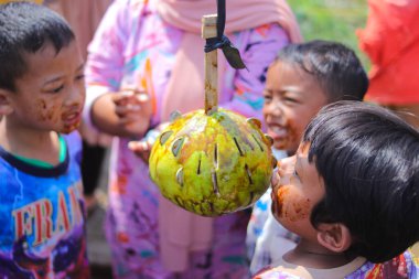 Sukabumi, Batı Java, Endonezya - 19 Ağustos 2021: Endonezyalı çocuklar SIGIT adı verilen geleneksel oyunlar oynuyorlar veya Endonezya Bağımsızlık Günü sırasında soya sosuyla kaplı portakal meyvelerinden madeni para alıyorlar