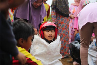 Sukabumi, Batı Java, Endonezya - 19 Ağustos 2021: Endonezyalı miğferli bir grup çocuk Endonezya 'nın Bağımsızlık Günü' nde Balap Karung veya Sack Race adlı geleneksel oyunlarıyla mücadele ediyor