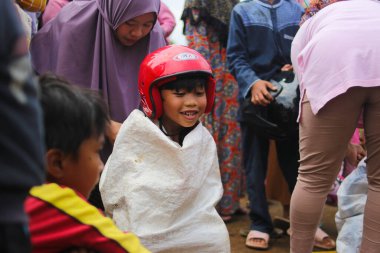 Sukabumi, Batı Java, Endonezya - 19 Ağustos 2021: Endonezyalı miğferli bir grup çocuk Endonezya 'nın Bağımsızlık Günü' nde Balap Karung veya Sack Race adlı geleneksel oyunlarıyla mücadele ediyor