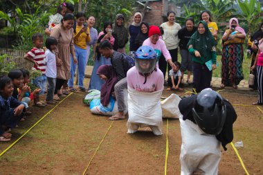 Sukabumi, Batı Java, Endonezya - 19 Ağustos 2021: Endonezyalı miğferli bir grup kadın Endonezya Bağımsızlık Günü 'nde Balap Karung veya Sack Race adlı geleneksel Endonezya oyunlarıdır.