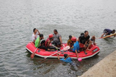 Sukabumi, Batı Java, Endonezya - 22 Ağustos 2021: Bir grup Endonezyalı kauçuk bir teknede ve bazıları Panjat Pinang direğinin suya düşmesi sonrasında suya düştü