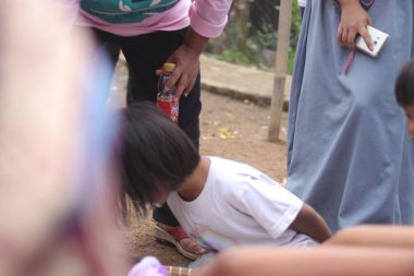 Sukabumi, Batı Java, Endonezya - 19 Ağustos 2021: Endonezyalı bir grup çocuk, Endonezya 'nın bağımsızlık gününde Nyiru adlı yiyecek konteynerinden para almak için yarışıyor.