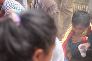 Sukabumi, Batı Java, Endonezya - 19 Ağustos 2021: Endonezyalı bir grup çocuk, Endonezya 'nın bağımsızlık gününde Nyiru adlı yiyecek konteynerinden para almak için yarışıyor.