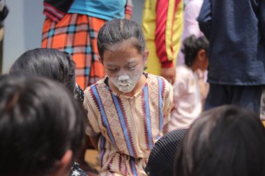 Sukabumi, Batı Java, Endonezya - 19 Ağustos 2021: Endonezyalı tatlı bir kızın yüzü, Endonezya 'nın bağımsızlık gününde Nyiru adlı bir yiyecek konteynerinden para almak için yarışırken buğday dolu.