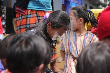 Sukabumi, Batı Java, Endonezya - 19 Ağustos 2021: Endonezyalı tatlı bir kızın yüzü, Endonezya 'nın bağımsızlık gününde Nyiru adlı bir yiyecek konteynerinden para almak için yarışırken buğday dolu.