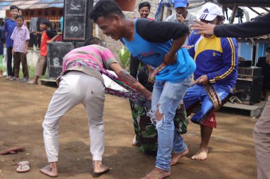 Sukabumi, Batı Java, Endonezya - 22 Ağustos 2021: Sarong kullanarak bağlanmış bir grup Endonezyalı, Endonezya Bağımsızlık Günü sırasında Tarık Sarong veya Tarık sarung adı verilen geleneksel bir oyunda birbirini çekiyor