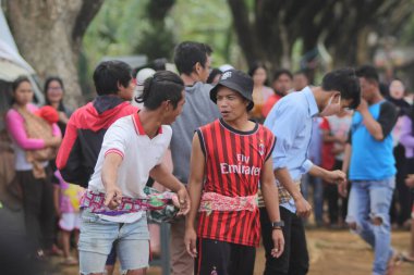 Sukabumi, Batı Java, Endonezya - 22 Ağustos 2021: Sarong kullanarak bağlanmış bir grup Endonezyalı, Endonezya Bağımsızlık Günü sırasında Tarık Sarong veya Tarık sarung adı verilen geleneksel bir oyunda birbirini çekiyor