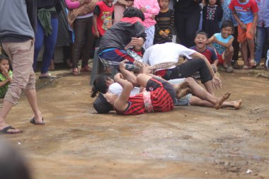 Sukabumi, Batı Java, Endonezya - 22 Ağustos 2021: Sarong kullanarak bağlanmış bir grup Endonezyalı, Endonezya Bağımsızlık Günü sırasında Tarık Sarong veya Tarık sarung adı verilen geleneksel bir oyunda birbirini çekiyor