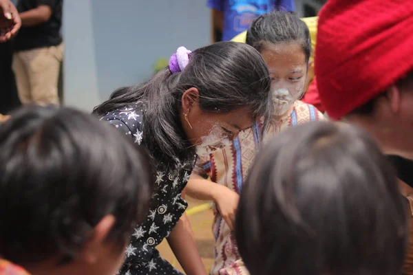 2021年8月19日インドネシア西ジャワ州スカブミ インドネシア独立記念日にニャルと呼ばれる食品容器からコインを取るために競合しながら かわいいインドネシアの女の子の顔は小麦でいっぱいです — ストック写真
