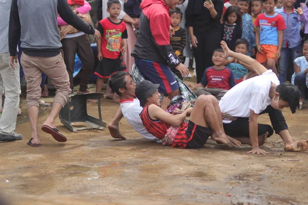 Sukabumi, Batı Java, Endonezya - 22 Ağustos 2021: Sarong kullanarak bağlanmış bir grup Endonezyalı, Endonezya Bağımsızlık Günü sırasında Tarık Sarong veya Tarık sarung adı verilen geleneksel bir oyunda birbirini çekiyor