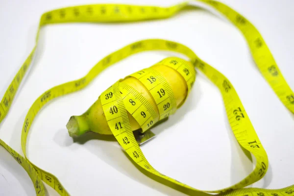 Small Banana Wrapped Measuring Tape Isolated White Background Conceptual Illustration — Stockfoto