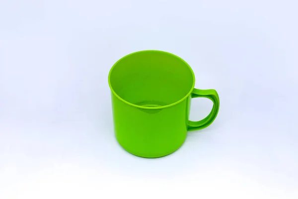 白い背景上に分離されて緑のプラスチック製マグカップ — ストック写真