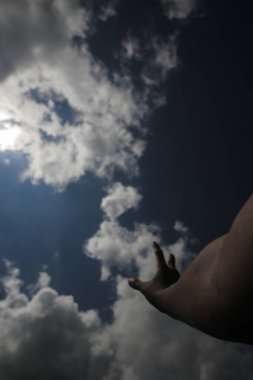 El, Stratocumulus bulutlarına ulaşmaya çalışıyor. Gün ortasında açık mavi bir gökyüzü arkaplanı var. Bulutların tipleri görüntü depoluyor. Rüya yakalayıcı konsepti.